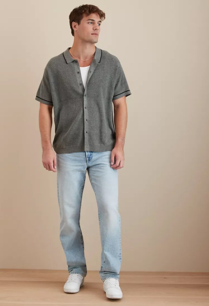 blonde guy wearing a gray button-up polo shirt and light wash jeans from American Eagle