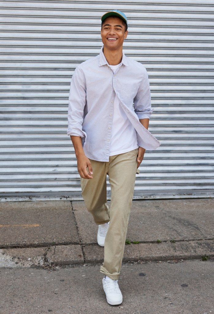 a guy wearing a blue baseball hat, white button-up shirt, and khaki pants from American Eagle