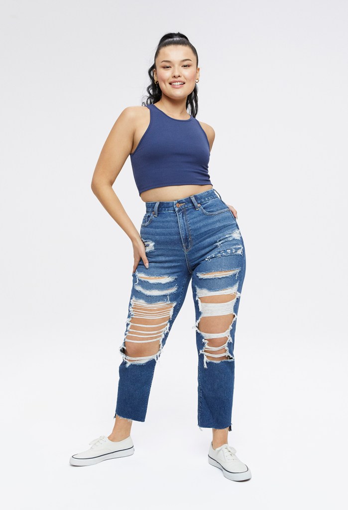 woman wearing a blue tank top and ripped Mom jeans in a dark wash