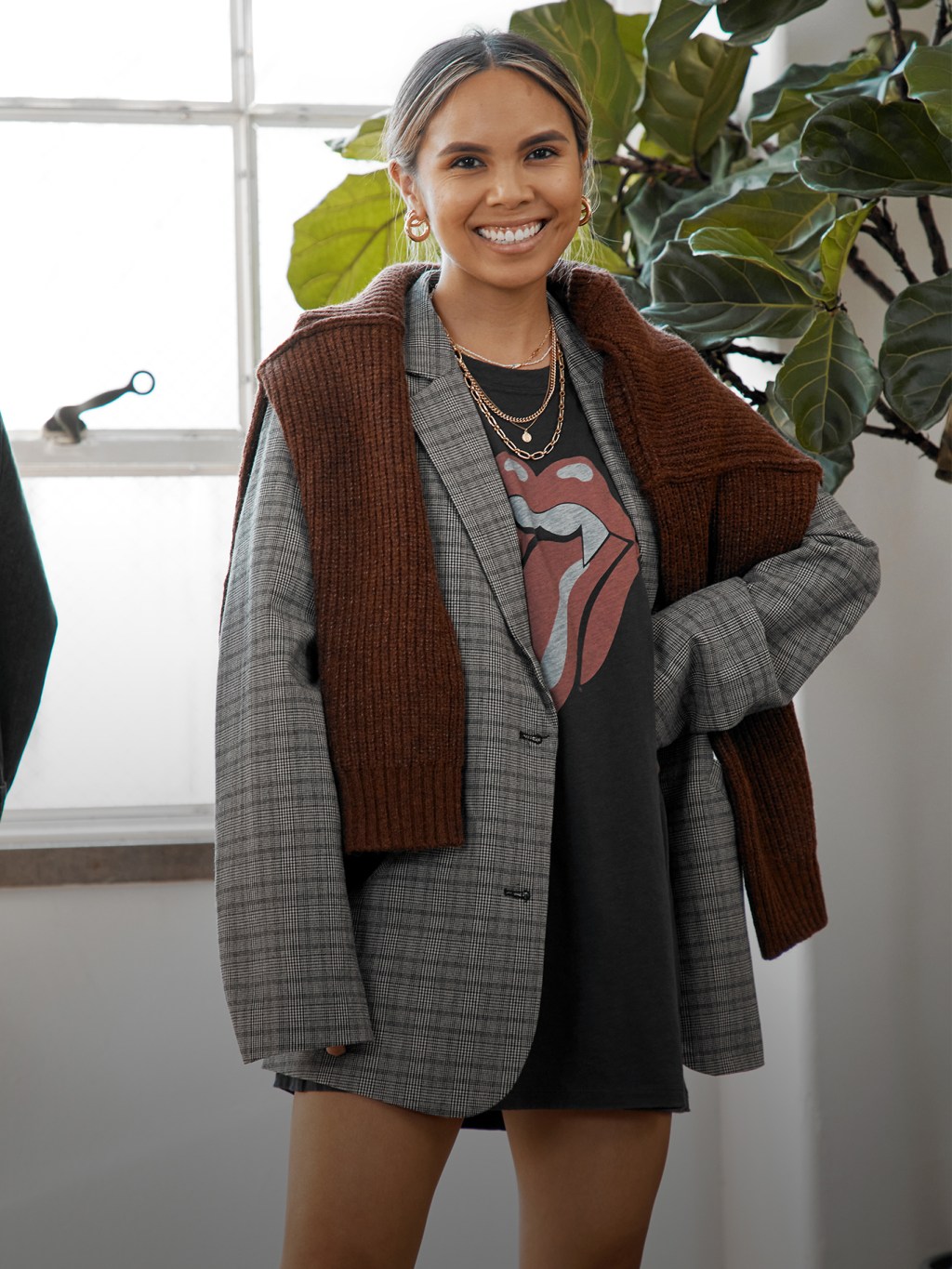 woman wearing black shorts, a plaid blazer, and graphic tee