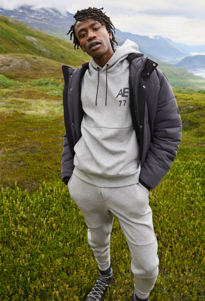 man wearing an AE hoodie and joggers with a coat