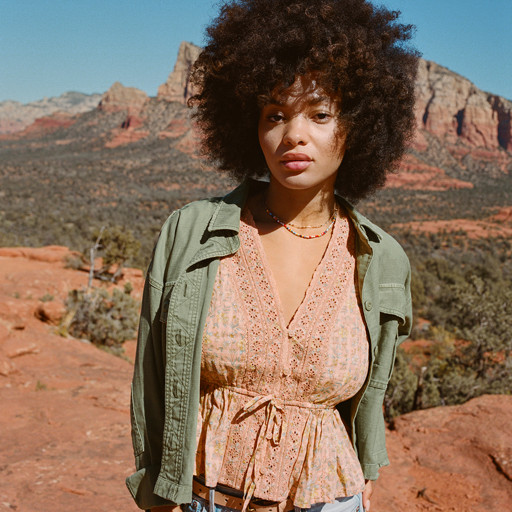 woman wearing an orange shirt with a green jacket