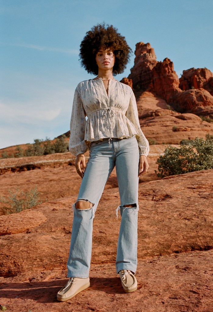 woman wearing light wash '90s bootcut jeans and a peasant top