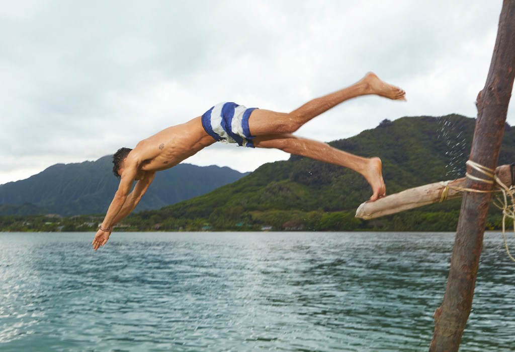 guy diving into water wearing striped American Eagle swim trunks