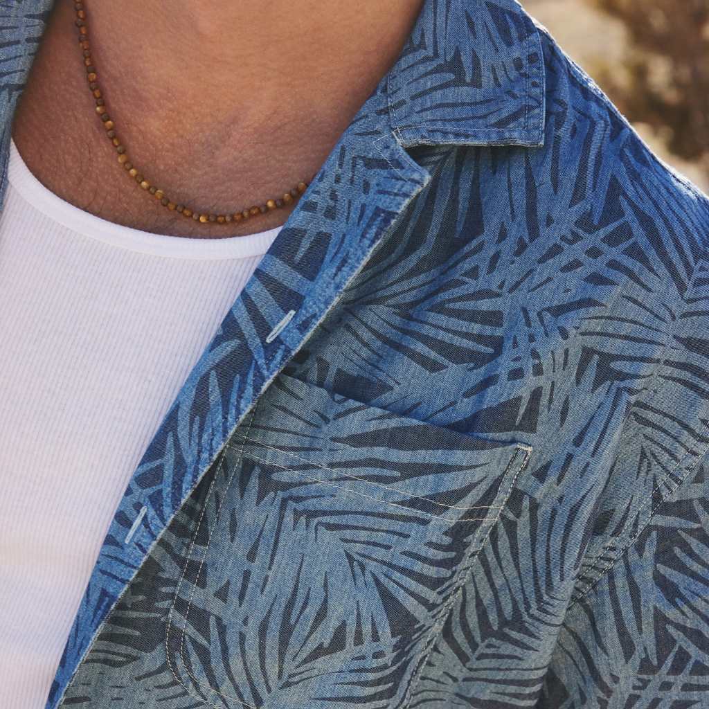 close up view of an unbuttoned Hawaiian shirt from American Eagle layered over a white tank top