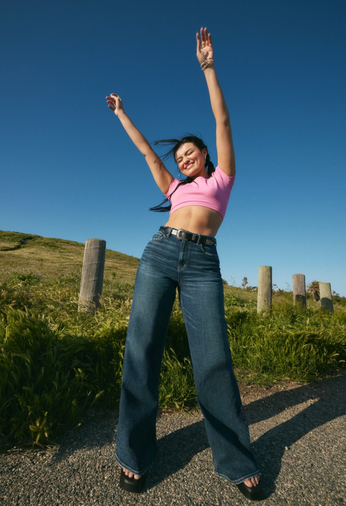 girl wearing a pink crop top and wide leg jeans from American Eagle