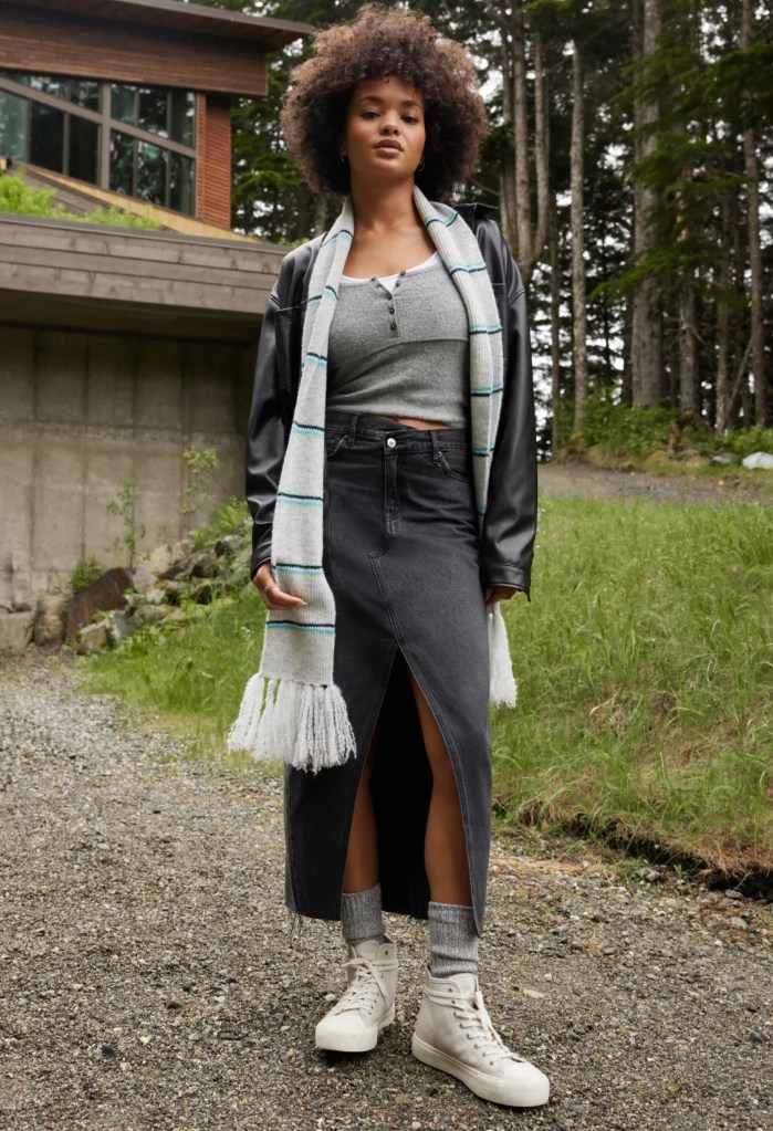 girl wearing a long black denim skirt, thermal top, and jacket from American Eagle standing outside in front of a house