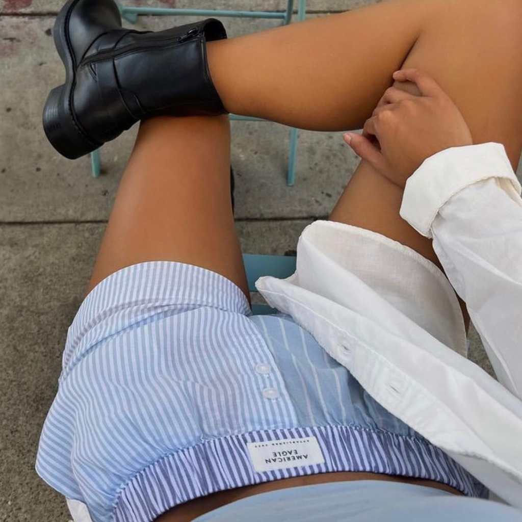 girl wearing blue american eagle boxer shorts, a button up shirt, and black boots