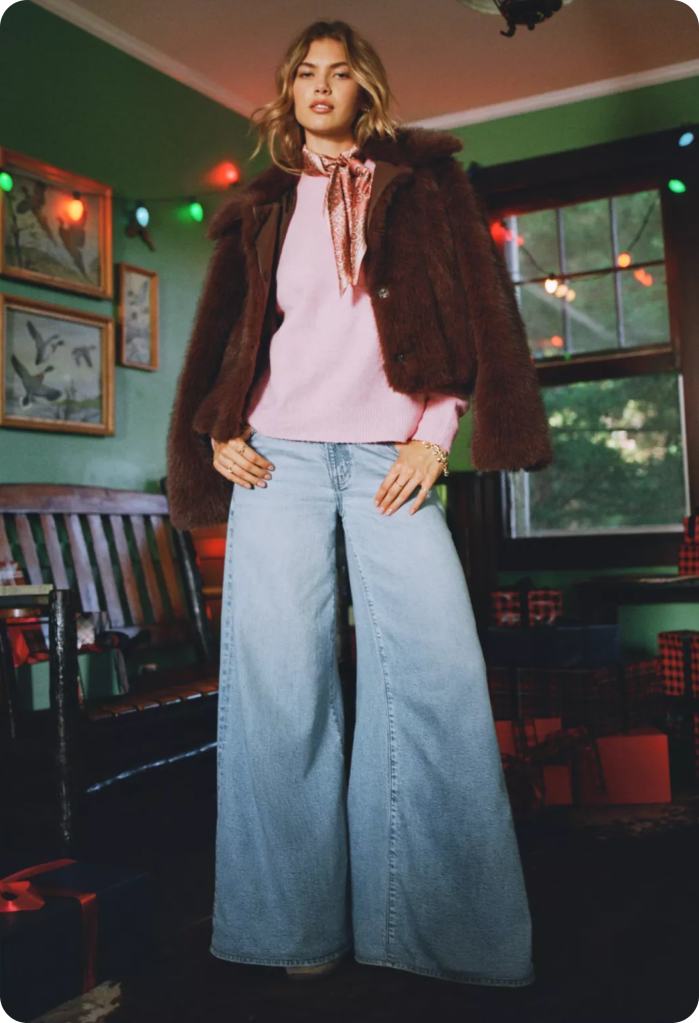 girl wearing a pink shirt, brown jacket, and blue baggy jeans from american eagle