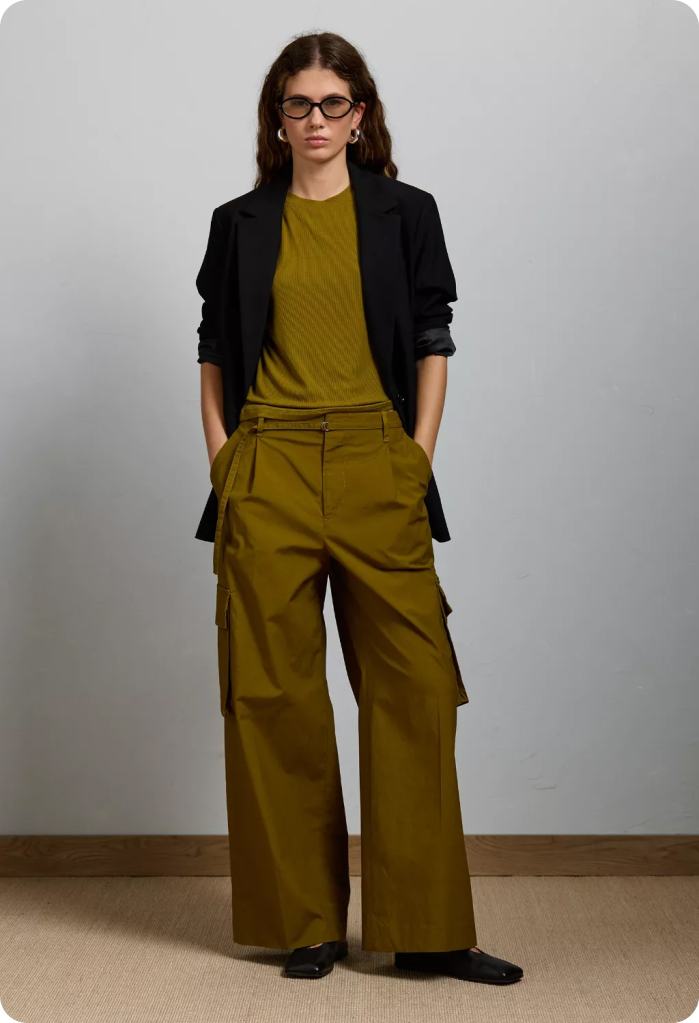 girl wearing trousers, a matching green top, and a black blazer office outfit from American Eagle