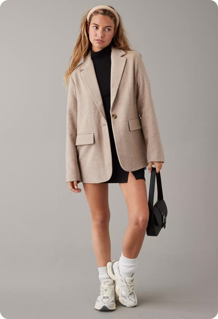 woman wearing a black skirt and tan blazer business casual outfit from American Eagle