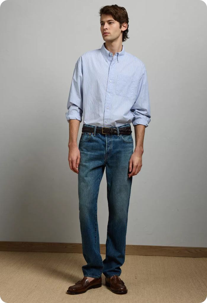 guy wearing an office outfit of a button up shirt tucked into blue jeans from American Eagle