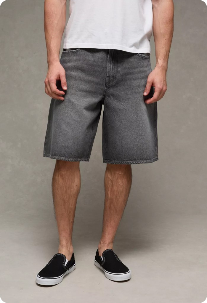 guy wearing black baggy jorts, a white t-shirt, and slip on sneakers from american eagle
