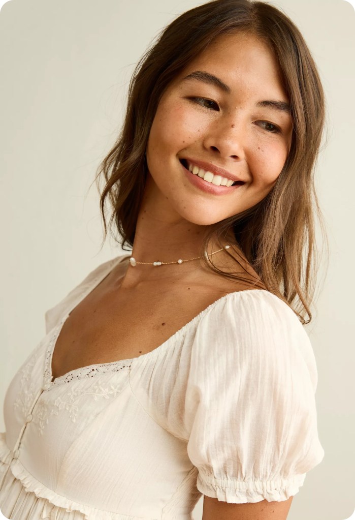 woman wearing a white babydoll dress from american eagle