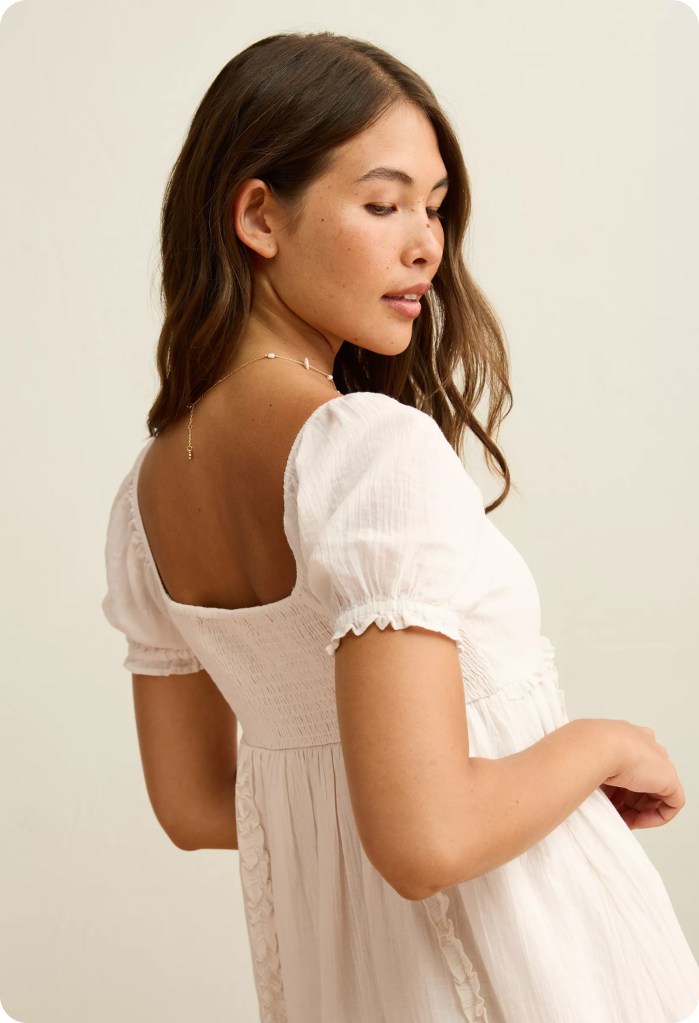 woman wearing a white babydoll dress from american eagle