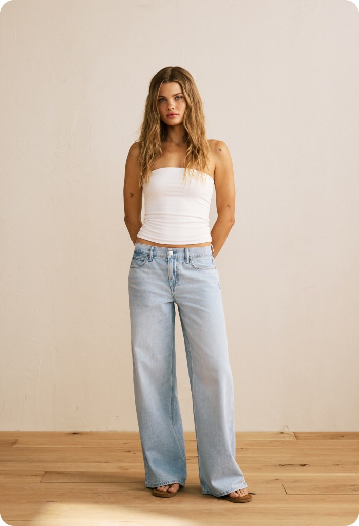 girl wearing a white tank top and baggy jeans from american eagle