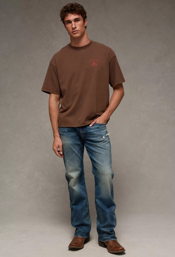 Male wearing dark wash jeans with brown cowboy boots and brown t-shirt